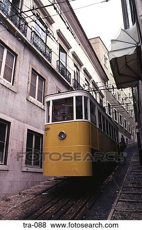 Stock Photo - Yellow Lisbon Tram Climbing Steep Incline Portugal. Fotosearch
