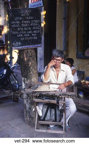 Picture - Man Reading at Table Hanoi Vietnam. Fotosearch