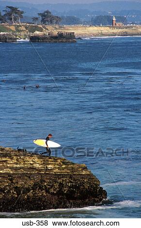 Man with Surf Board on Rock Outcrop USA View Large Photo Image Stock Photo - Man with Surf Board on Rock Outcrop USA. Fotosearch