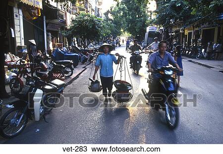 Stock Image - Pedestrians and Mopeds Hanoi Vietnam. Fotosearch