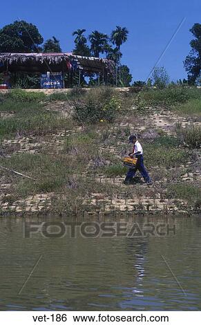 Schoolboy Walking on Riverbank Hue Vietnam View Large Photo Image Stock Photograph - Schoolboy Walking on Riverbank Hue Vietnam. Fotosearch