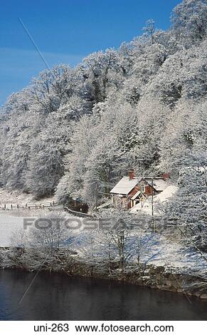 Stock Image - Snow Covered Cottage and Trees Wales UK. Fotosearch