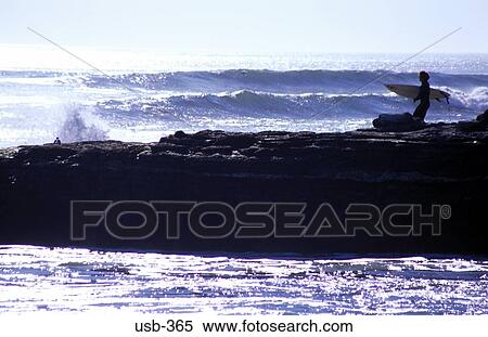 Stock Photography - Surfer Carrying Board Silhouetted against Sea USA. Fotosearch