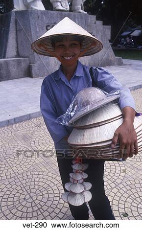 Stock Image - Woman Carrying Conical Hats Hanoi Vietnam. Fotosearch