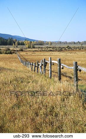 Stock Image - Wood Fence through Field Wyoming USA. Fotosearch