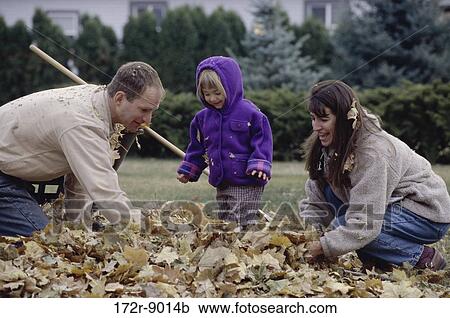 Stock Image - leaves, people, autumn, playing, outdoors, family, kneeling. Fotosearch