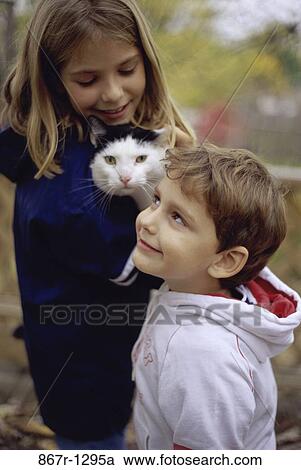 Stock Image - people, cat, pet, outdoors, children, brunette, Caucasian. Fotosearch