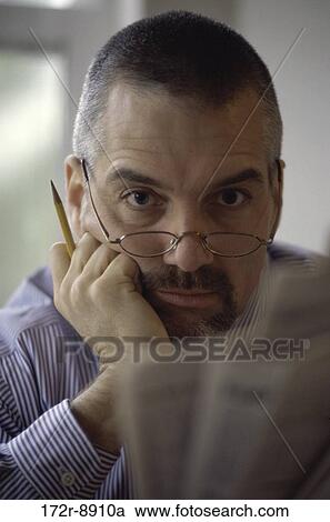 people, newspaper, staring, eyeglasses, pencil, reading View Large Photo Image Stock Image - people, newspaper, staring, eyeglasses, pencil, reading. Fotosearch