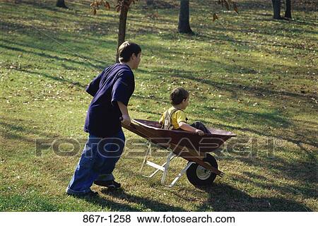 people, riding, wheelbarrow, outdoors, children, boys, pushing View Large Photo Image Stock Photo - people, riding, wheelbarrow, outdoors, children, boys, pushing. Fotosearch