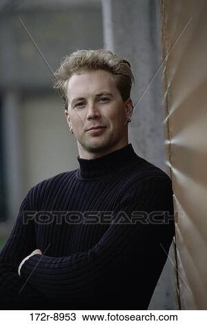 Stock Image - people, sweater, leaning, outdoors, wall, earrings. Fotosearch