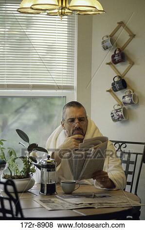 Stock Photo - people, table, newspaper, eyeglasses, reading, Middle-aged. Fotosearch