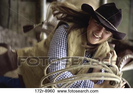 Stock Image - people, woman, rope, hat, western, outdoors. Fotosearch