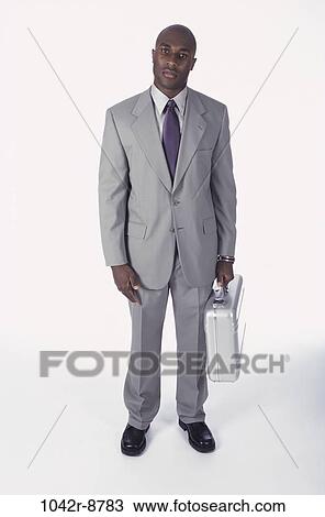 Stock Image - briefcase, business, businessman, indoors, African-American, young adult. Fotosearch