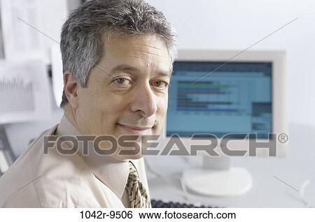 Stock Photograph - computer, business, Middle-aged, businessman, indoors, Caucasian. Fotosearch
