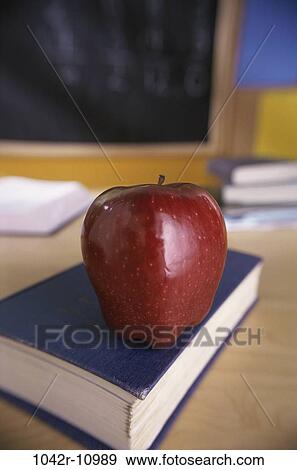 Stock Photo - desk, apple, school, classroom, book, education, still life. Fotosearch