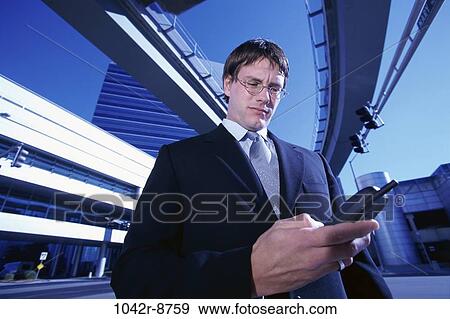 Stock Photo - dial, dialing, eyeglasses, phone, business, outdoors. Fotosearch