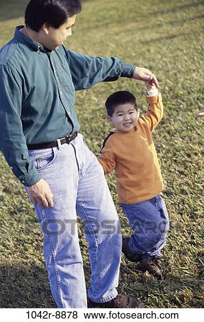 Stock Photo - grass, people, walking, Asian, outdoors, family. Fotosearch
