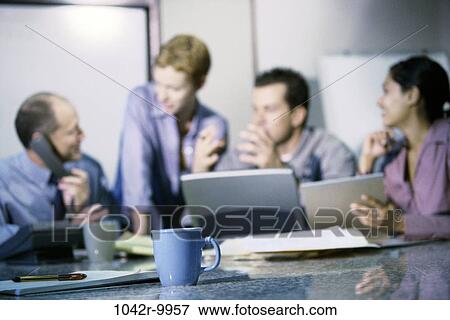 Stock Photo - meeting, group, multiethnic, men, women, telephone, table. Fotosearch