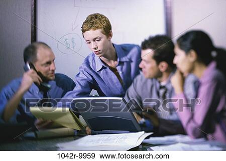 Stock Photo - meeting, group, multiethnic, men, women, papers, computer. Fotosearch