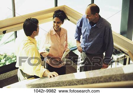 Stock Image - meeting, group, multiethnic, stairs, coworkers, talking, discussion. Fotosearch