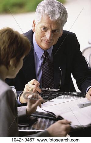 Stock Photo - meeting, paperwork, discussion, listening, business, outdoors, Middle-aged. Fotosearch