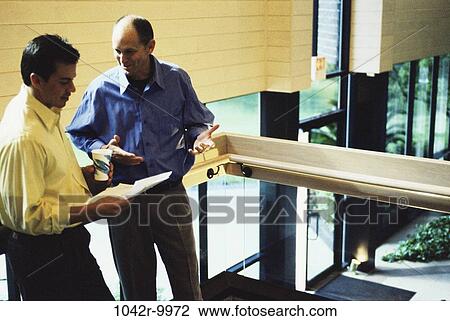 Stock Image - men, conversation, papers, business, Middle-aged, businessmen, together. Fotosearch