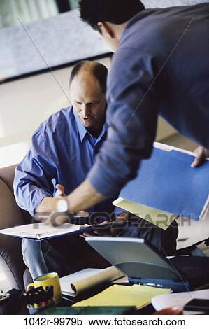 Stock Image - men, desk, laptop, business, Middle-aged, businessmen, indoors. Fotosearch