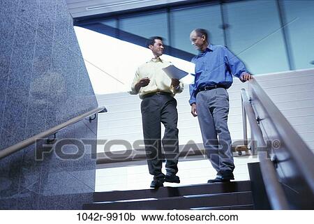 Stock Image - men, stairs, business, Middle-aged, businessmen, indoors, Caucasian. Fotosearch