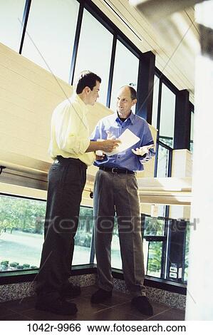 Stock Photograph - men, stairs, paper, conversation, business, Middle-aged, businessmen. Fotosearch