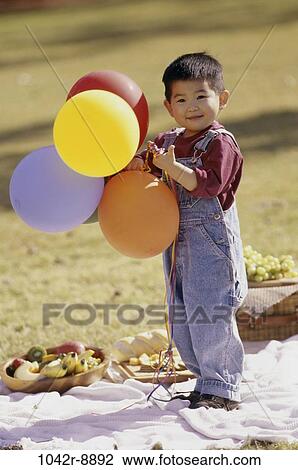Stock Image - people, Asian, baby, balloons, fruit, picnic, toddler. Fotosearch