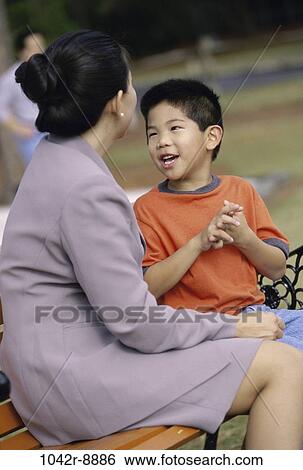 Stock Photograph - people, Asian, bench, sitting, mother, outdoors, family. Fotosearch