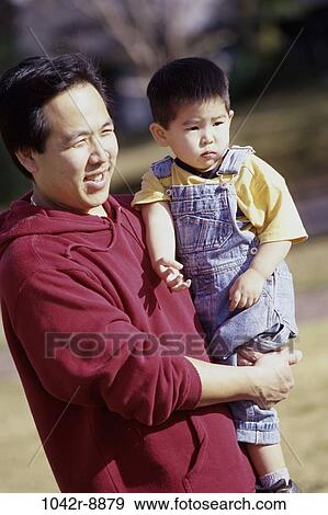Stock Photo - people, Asian, outdoors, arms, carrying, family. Fotosearch