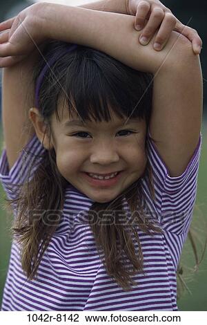 Stock Image - people, Asian, stretching, girl, outdoors, arms, child. Fotosearch