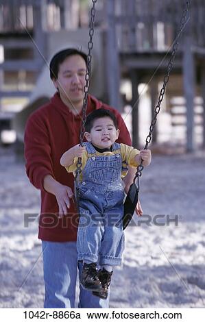 Stock Image - people, Asian, swinging, swing, playground, outdoors, park. Fotosearch