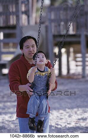 Stock Image - people, Asian, swinging, swing, playground, outdoors, park. Fotosearch