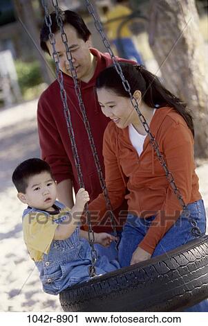 Stock Image - people, Asian, swinging, swing, playground, outdoors, park. Fotosearch