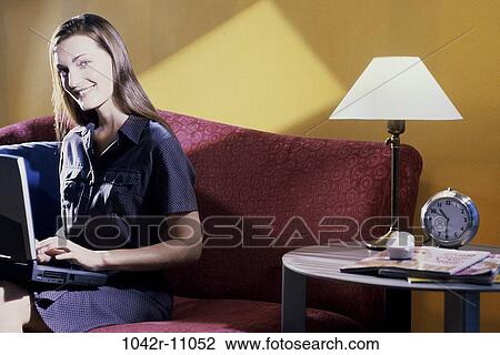 Stock Image - people, clock, woman, smiling, table, lamp, sitting. Fotosearch