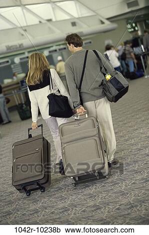 Stock Image - people, couple, luggage, vacation, indoors, travel, airport. Fotosearch