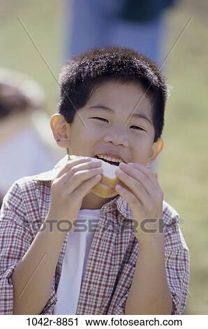 Stock Image - people, eating, Asian, boy, outdoors, child, lunch. Fotosearch
