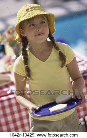 Stock Photo - people, eating, hat, plate, hamburger, girl, outdoors. Fotosearch