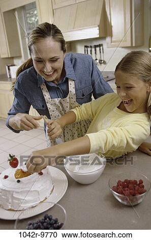 Stock Image - people, home, mother, cooking, cake, family, food. Fotosearch
