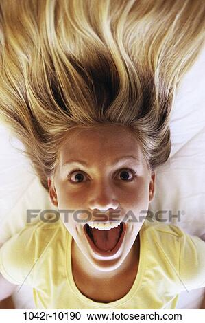 Stock Image - people, joyous, surprise, blond, indoors, teenager. Fotosearch