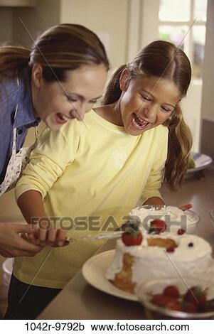 Stock Image - people, mother, cooking, cake, family, food, daughter. Fotosearch