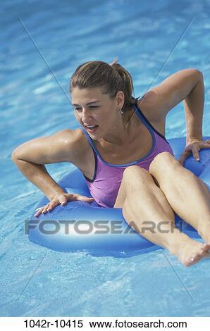 Stock Photography - people, pool, woman, outdoors, brunette, float. Fotosearch