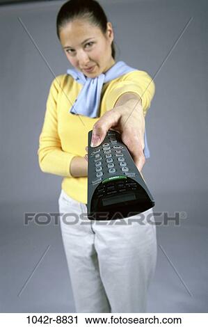 Stock Image - people, woman, Asian, watch, watching, television, remote. Fotosearch