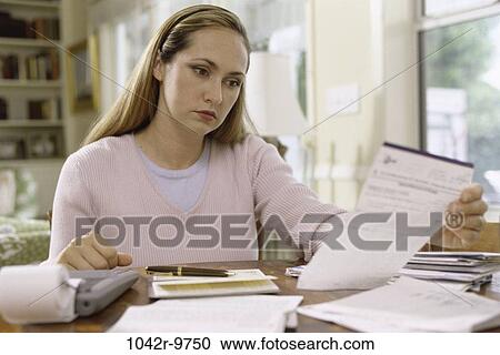 Stock Image - people, woman, calculator, Middle-aged, finance, bills, personal finance. Fotosearch