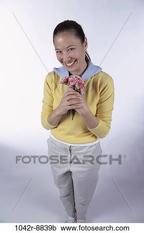 Stock Image - people, woman, Hispanic, flowers, brunette, indoors, young adult. Fotosearch