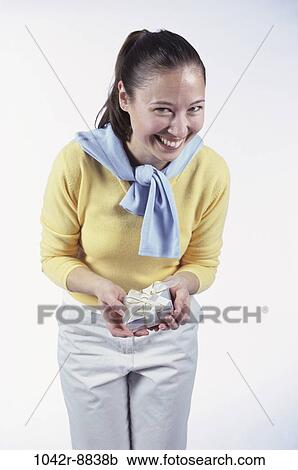 Stock Image - people, woman, Hispanic, surprise, gift, brunette, indoors. Fotosearch