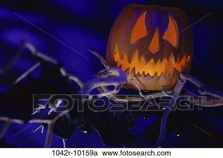 Stock Image - pumpkin, Halloween, branches, still life, scary, decoration, carved. Fotosearch