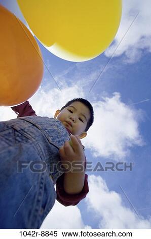 Stock Photography - sky, people, clouds, Asian, balloons, boy, outdoors. Fotosearch